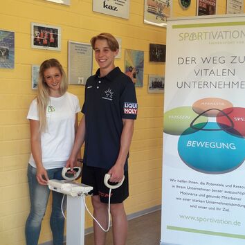 Eislöwenspieler steht auf einer BIA Waage und bekommt eine Beratung einer SPORTIVATIONs Mitarbeiterin