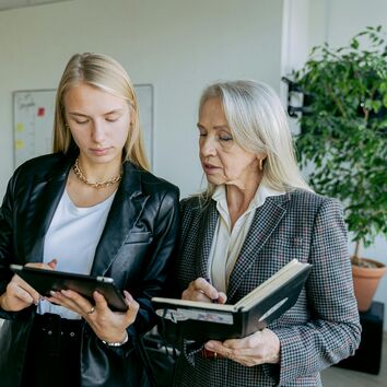 Junge Auszubildende lern von erfahrener Mitarbeiterin
