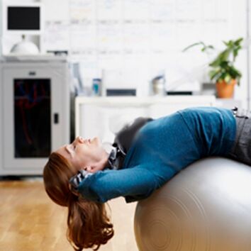 Frau liegt rücklings auf Gymnastikball